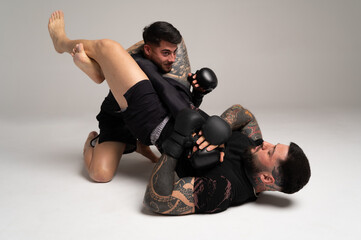 Mma fighters sparring and practicing a submission hold