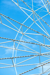 A close-up of a Ferris Wheel with a blue sky in the background 