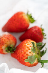 Fresh and Moldy Strawberries in a Glass Bowl on a White Napkin