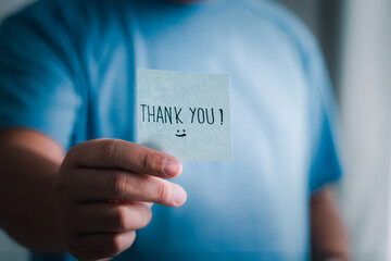 Grateful hand holding thank you note indoor space emotional gesture personal connection