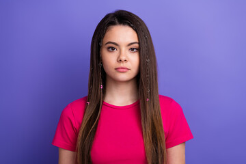 Young girl in casual pink attire posing against a vibrant purple background