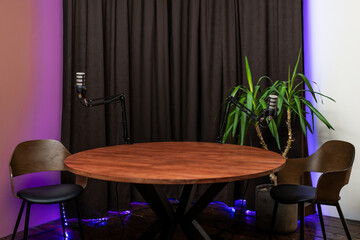 Discussion setup with microphones and headphones for podcasting in a cozy studio environment