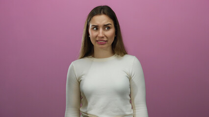 Woman expressing different emotions against an isolated pink background wall showcasing a range of...