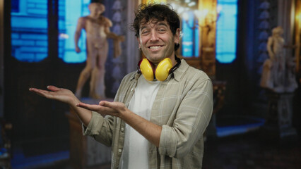Hispanic man with headphones gestures in a dimly lit museum gallery featuring classical statues in...