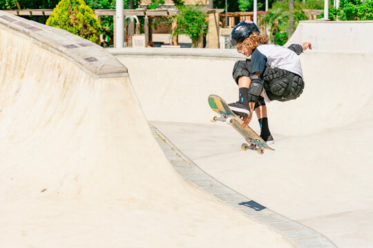 Young boy performing a jump on his skateboard at the skatepark