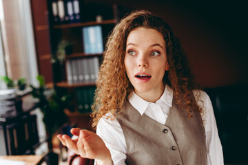 Young Businesswoman Discussing Ideas in a Bright Office Setting with Enthusiastic Expression
