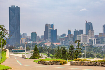 Central business district with modern skyscrapers of downtown of Addis Ababa road and green park in the foreground, Ethiopia