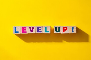 Colorful Level Up text on wooden blocks over bright yellow background.