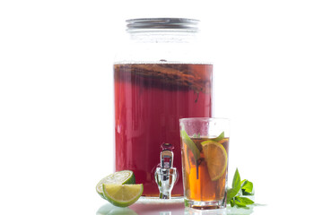 Golden kombucha with bubbles and greenery on white background