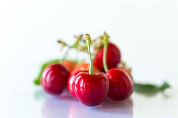 a handful of ripe red cherries on a white background
