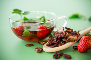 Aromatic herbal drink with berries on a green background