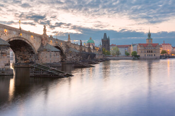 Charles Bridge with towers and sculptures at dawn in Prague, Czech Republic