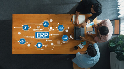 Aerial view of a business meeting focused on ERP systems. Team members discuss strategies and tools...