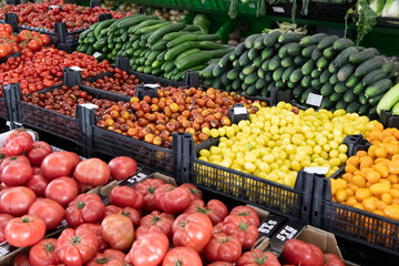 Colorful vegetables display at farmers market with tomatoes and cucumbers