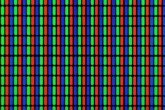 Close up view of colorful RGB pixel pattern on screen, showing red, green, and blue subpixels in repetitive grid. vibrant display highlights intricate design of digital screens