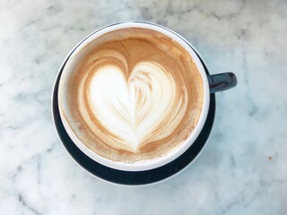 Heart-Shaped Latte Art in Black Cup on Marble Table

