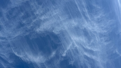 Thin translucent threads of clouds against the blue sky.