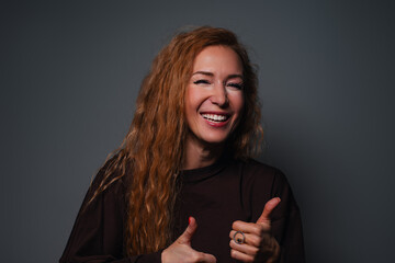 Young laughing woman studio portrait on gray background