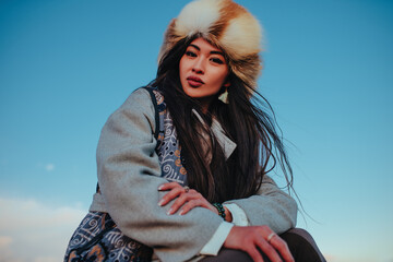 Young traditional kyrgyz woman portrait on blue sky background