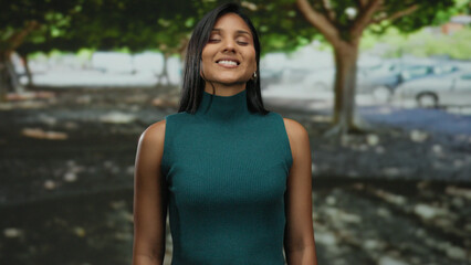 Woman enjoying peaceful moment with eyes closed in a sunny park setting, exuding calm and contentment in a serene outdoor environment.