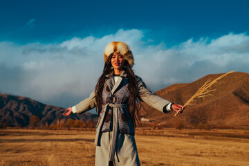 Young traditional kyrgyz woman portrait in the mountains at sunset light