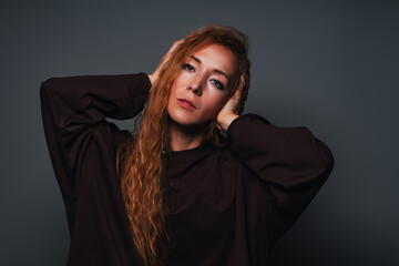 Young woman plugs her ears emotional portrait on gray background