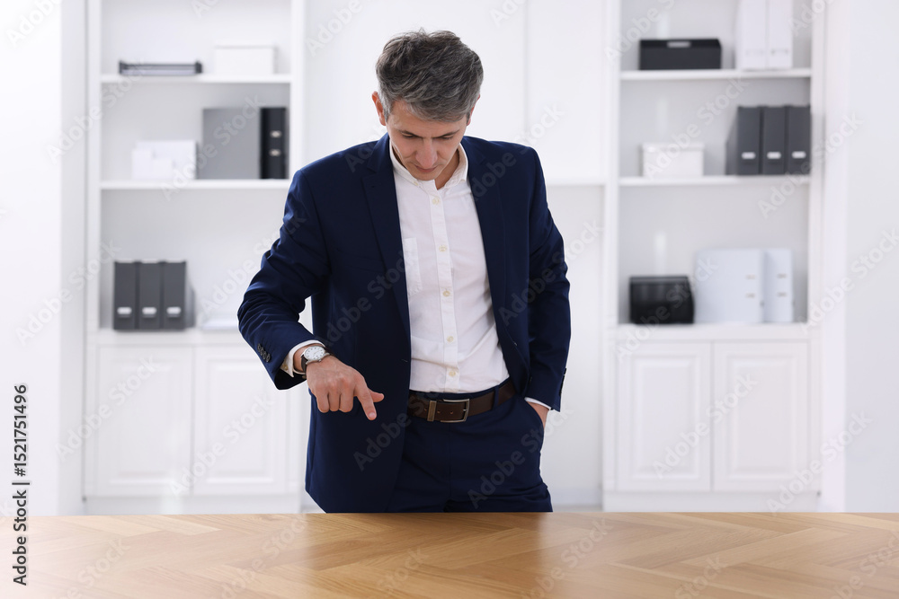 Poster man pointing at something on desk in office