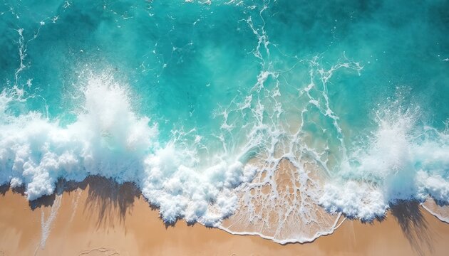 Aerial top view of turquoise ocean water with foamy waves splashing sandy shore. Beautiful seascape, white sea foam, blue water, splash. Tropical beach coast summer vacation concept.