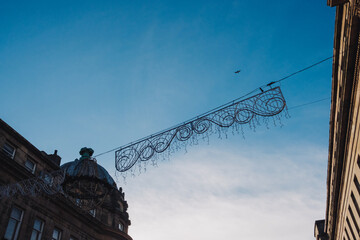 Newcastle UK: 22 Nov 2024: Christmas decorations going up Newcastle Grainger town. Newcastle prepares for festive decorations with intricate lights against the sky