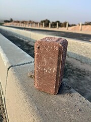Close-up of brick on concrete barrier along a road