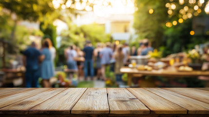 Wooden table with blurred backyard barbecue party and people socializing at sunset.
