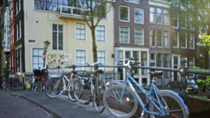 Defocused image of bicycles parked along a canal in amsterdam, netherlands, with a bokeh effect...