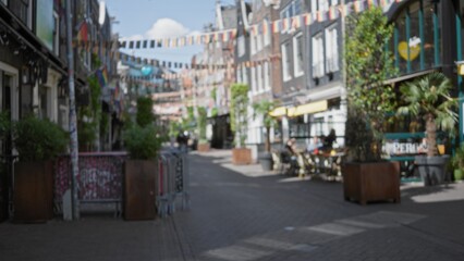 Naklejka premium Blurred street scene in amsterdam with colorful flags and bokeh effect creating a vibrant cityscape atmosphere.