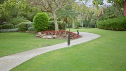 Blurred path leading through a lush, tropical garden in a luxury resort with vibrant greenery and...