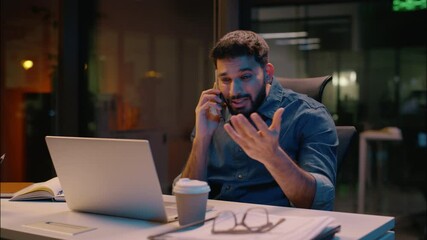Angry stressed Indian man businessman business entrepreneur boss mad problem laptop working talking mobile phone in evening night office displeased guy male arguing stress conflict smartphone call - Powered by Adobe