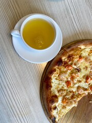a cup of tea and pizza are on the table