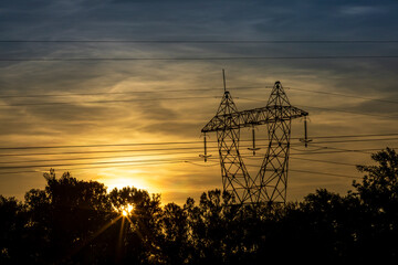 High voltage pylon in the French countryside at sunset. 400 kV High voltage electric power grid.