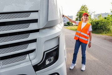 Portrait young adult happy smiling woman heavy truck driver modern cargo vehicle cabin background. Female person girl professional job career working driving freight engine lorry. Logistics industry