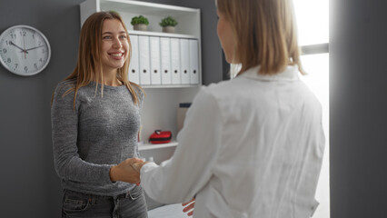 Doctor greeting smiling patient in a modern hospital room, showcasing a professional interaction...