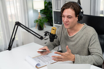 Host channel in smiling smart broadcaster recording, talking show with script and smartphone on...