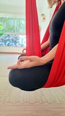 Woman practicing aero yoga at small room