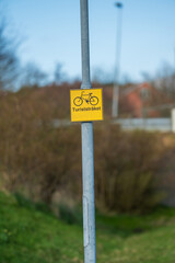 Yellow cycling route sign for tourists.