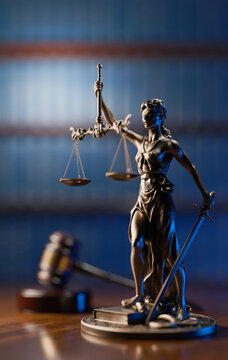 Legal Concept: Themis is the goddess of justice and the judge's gavel hammer as a symbol of law and order on the background of books