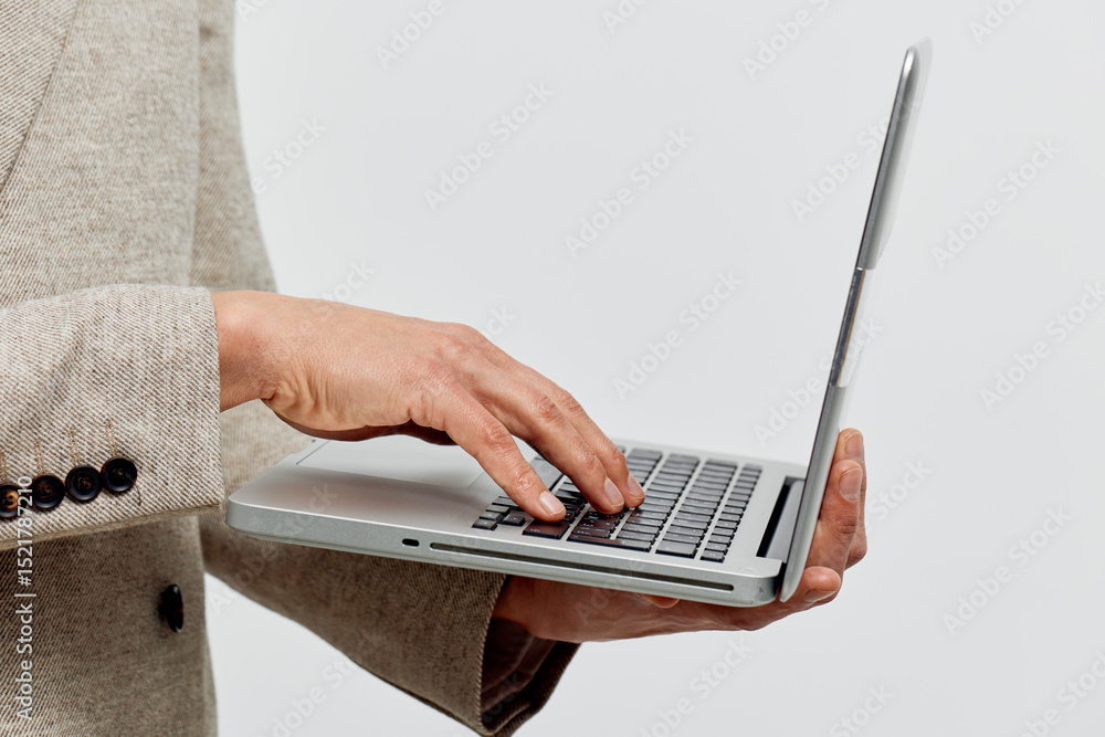 Poster man working on laptop holding portable computer typing fingers close up minimalistic gray background