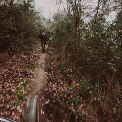 Chasing another rider on a cross country mountain bike race rider point of view inside a forest on a mountain bike trail