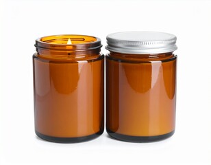 Dos velas aromáticas en frascos de vidrio ámbar con tapa metálica, una encendida, ambas sobre fondo blanco, estilo acogedor.