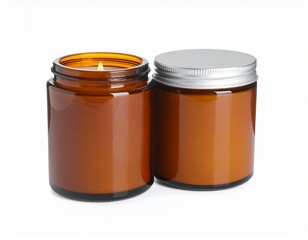 Dos velas aromáticas en frascos de vidrio ámbar con tapa metálica, una encendida, ambas sobre fondo blanco, estilo acogedor.