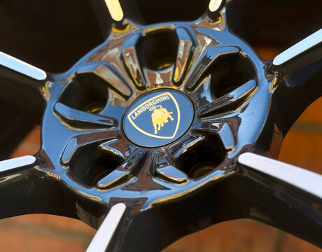 Close up view of a luxury black and silver Lamborghini supercar alloy wheel rim showcasing the iconic brand shield center cap logo.
