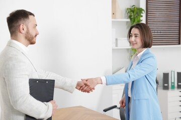 Fototapeta premium Recruiter and candidate shaking hands in office