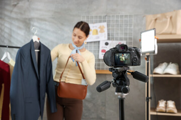 Professional stylist filming video on camera indoors, selective focus